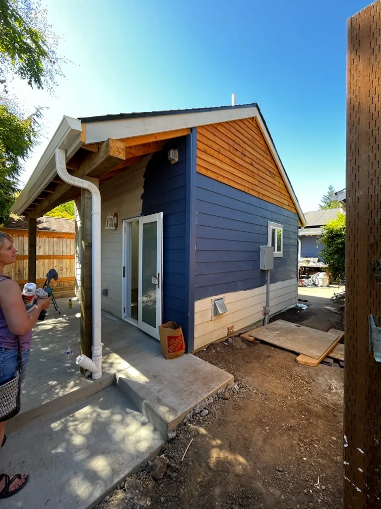 Blue lap siding and cedar gable siding being installed on a home addition